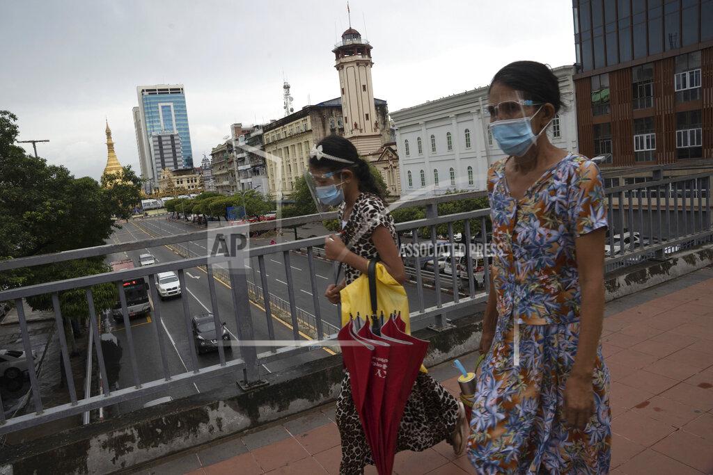 Pyae Sone Win Pedestrians wearing face shields and masks walk at an overhead crossing at Sule Pagoda Road in Yangon, Myanmar,Monday, Sept. 21, 2020. Myanmar, faced with a rapidly rising number of coronavirus cases and deaths, has imposed the tightest restrictions so far to fight the spread of the disease in Yangon, the country's biggest city and main transportation hub. (AP Photo/Pyae Sone Win)