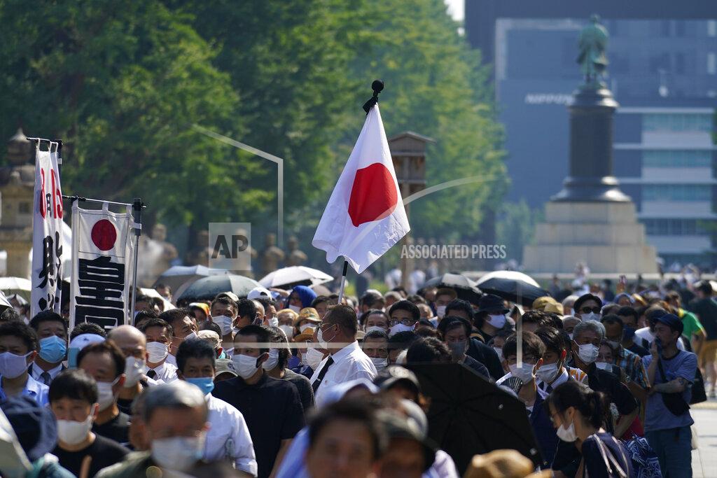 Worshippers queue to pay respects to the war dead at Yasukuni Shrine Saturday, Aug. 15, 2020, in Tokyo. Japan marked the 75th anniversary of the end of World War II. (AP Photo/Eugene Hoshiko)