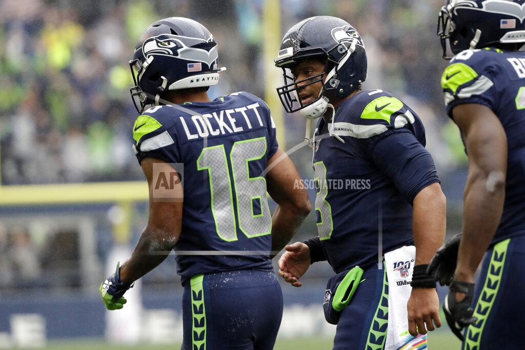 Elaine Thompson Seattle Seahawks quarterback Russell Wilson, center, greets wide receiver Tyler Lockett (16) after Lockett caught a pass from him for a touchdown against the Baltimore Ravens during the first half of an NFL football game, Sunday, Oct. 20, 2019, in Seattle. (AP Photo/Elaine Thompson)