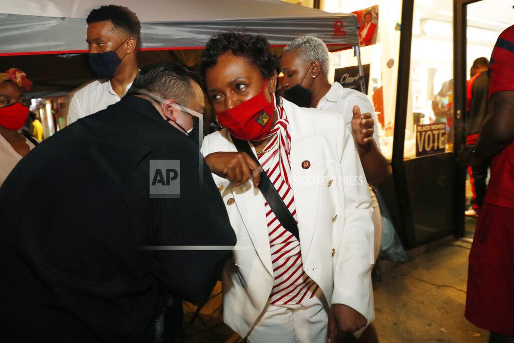 Kathy Willens A supporter, left, congratulates Rep. Yvette Clarke, D-N.Y., with an elbow bump at the campaign headquarters of veteran congresswoman Tuesday, June 23, 2020, in the Brooklyn borough of New York, as primary results continued to be tallied. (AP Photo/Kathy Willens)