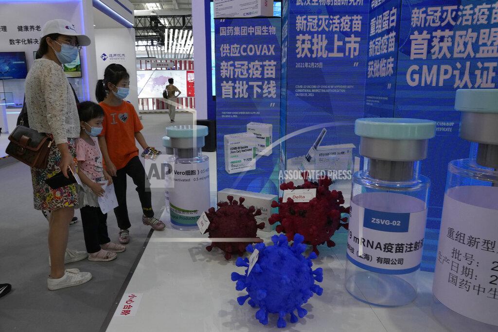 Ng Han Guan Visitors look at giant replica bottles of COVID-19 vaccine including one produced via mRNA technology by Sinopharm subsidiary CNBG at the China International Fair for Trade in Services (CIFTIS) in Beijing, China on Sept. 5, 2021. More than two years into the pandemic, China has not approved the more effective mRNA vaccines, instead choosing to pursue its own route on COVID-19 vaccines. (AP Photo/Ng Han Guan)