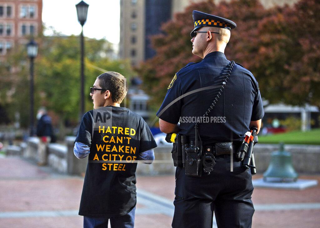 Jessie Wardarski Sam Goldston, of Squirrel Hill, left, stands with police officer Andrew Hohol as people enter Soldiers and Sailors Memorial Hall and Museum for a public memorial service in Pittsburgh on Sunday, Oct. 27, 2019, honoring the lives of the 11 victims killed a year ago in the Tree of Life shooting. (Jessie Wardarski/Pittsburgh Post-Gazette via AP)