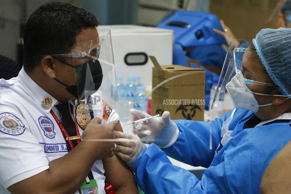 Aaron Favila A security guard is inoculated with China's Sinovac COVID-19 vaccine at the Navotas Fish Port, Philippines on Monday, June 7, 2021. The government today bolstered its vaccination program by including frontline economic personnel both in private and government sectors. (AP Photo/Aaron Favila)