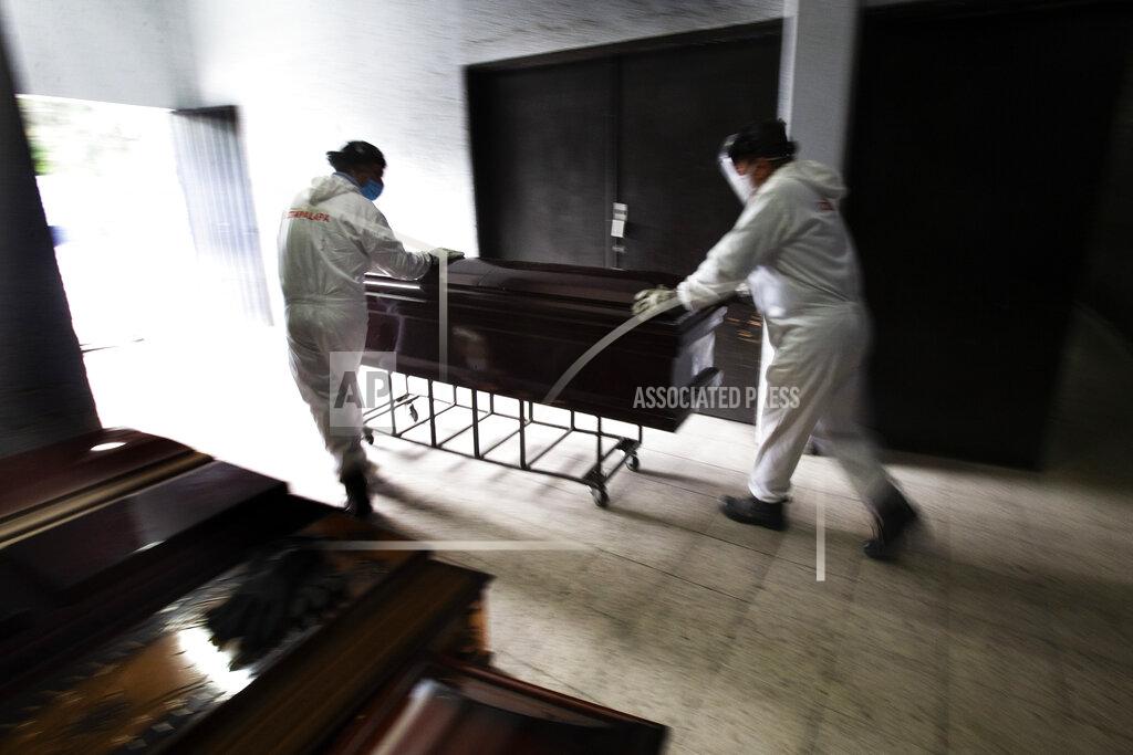 Marco Ugarte FILE - In this June 4, 2020 file photo, workers in protective gear as a precaution against the coronavirus, remove a coffin that contained the remains of a person who died from the coronavirus, at the crematorium inside the San Nicolas Tolentino cemetery in the Iztapalapa borough of Mexico City. As Mexico approaches 200,000 in officially test-confirmed deaths from COVID-19, the real death toll is probably higher due to the country’s extremely low rate of testing. (AP Photo/Marco Ugarte, File)