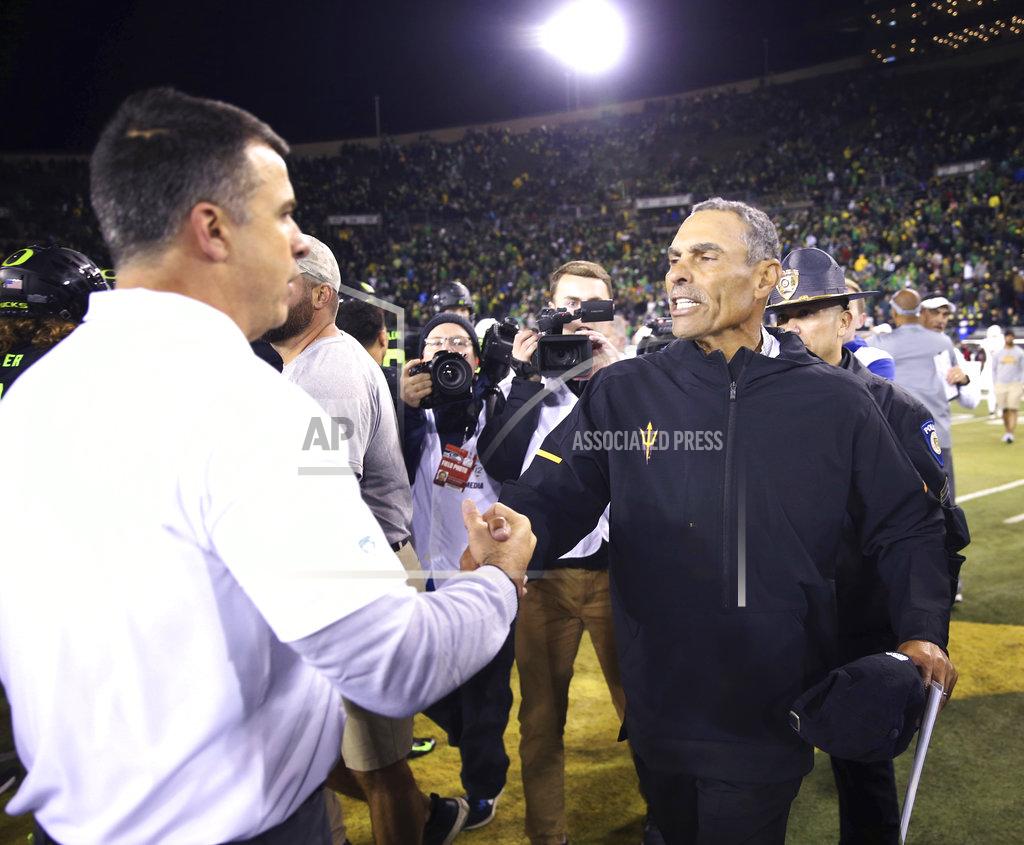Chris Pietsch Oregon head football coach Mario Cristobal, left, meets Arizona State head football coach Herm Edwards at midfield after the Duck's won the game 31-28 in an NCAA college football game Saturday, Nov. 17, 2018, in Eugene, Ore. (AP Photo/Chris Pietsch)