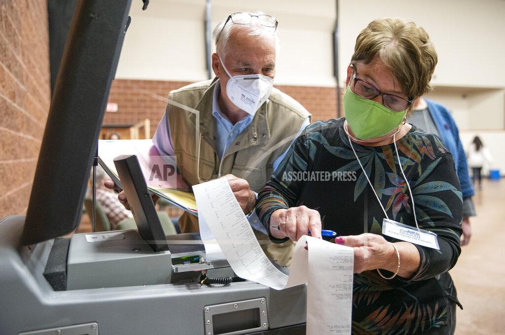 Alex Kormann John Keenan, left, and Kathie Trotta, Duluth's 11th precinct co-head polling judges, read off the in-person ballot counts for the presidential and U.S. Senate races to an Associated Press representative after the polls closed, Tuesday, Nov. 3, 2020, in Duluth, Minn. (Alex Kormann/Star Tribune via AP)