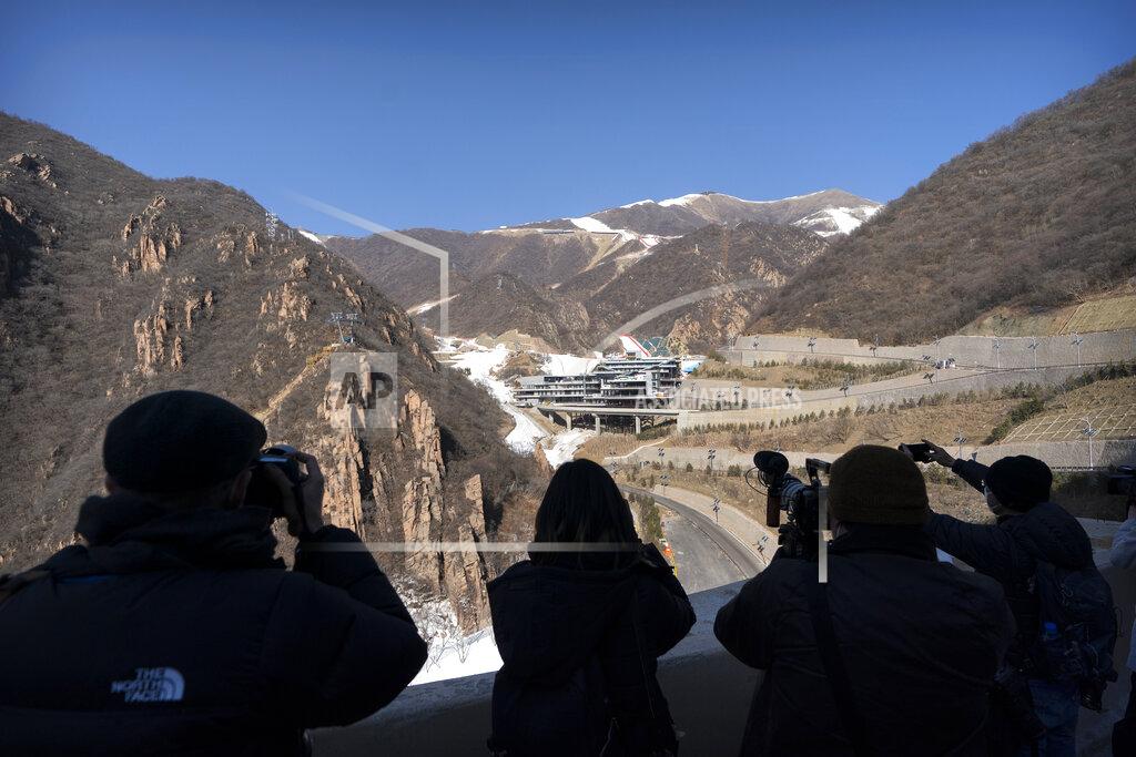 Mark Schiefelbein Journalists take photos of the National Alpine Skiing Center in Yanqing on the outskirts of Beijing, Friday, Feb. 5, 2021. Beijing Olympic organizers showed off the downhill skiing venue and the world's longest bobsled and luge track Friday, one year ahead of the scheduled opening of the 2022 Olympic Winter Games. (AP Photo/Mark Schiefelbein)