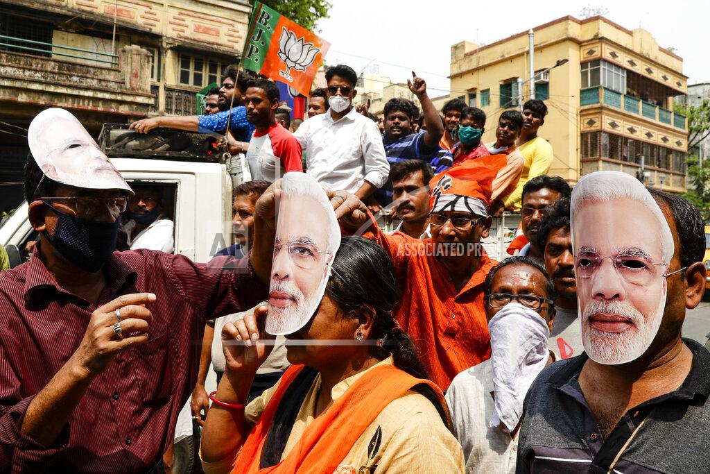 Bikas Das FILE - In this March 20, 2021, file photo, supporters of Bharatiya Janata Party wearing masks bearing the likeness of Prime Minister Narendra Modi participate in a campaign rally ahead of elections in West Bengal state in Kolkata, India. Despite clear signs that India was being swamped by another surge of coronavirus infections, Modi refused to cancel the rallies, a major Hindu festival and cricket matches with spectators. The burgeoning crisis has badly dented Modi’s carefully cultivated image as an able technocrat. (AP Photo/Bikas Das, File)