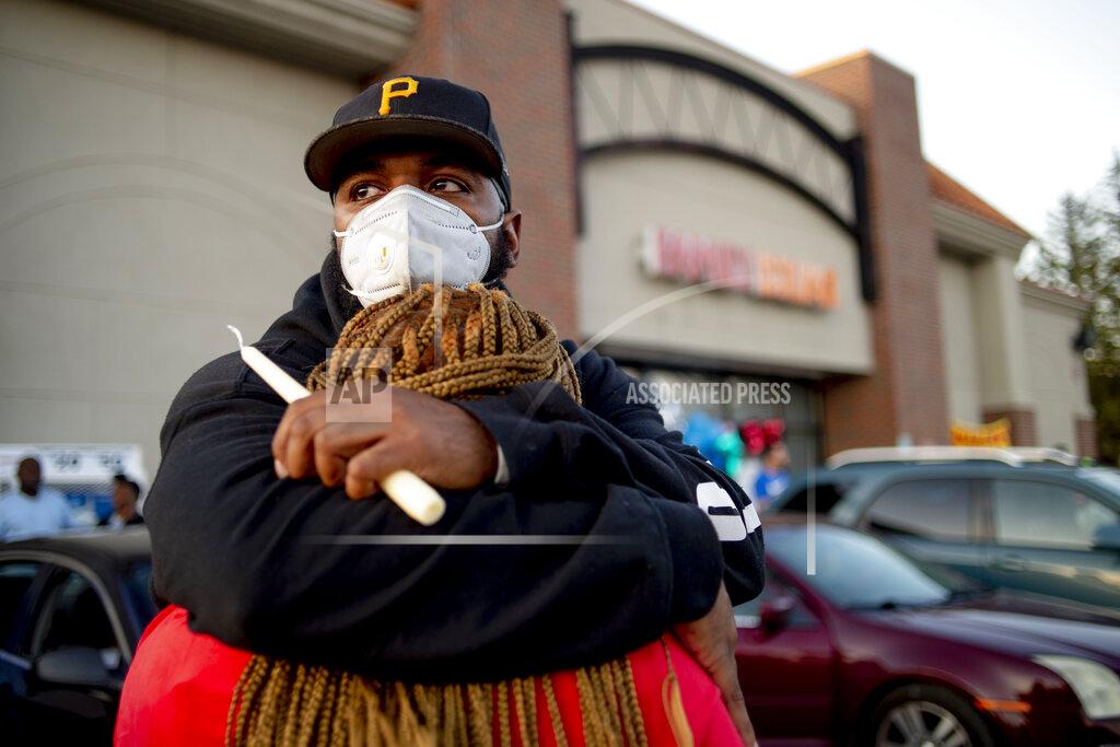 Jake May Pete Tedford, cousin, of Calvin Munerlyn, and Dorothy Nelson, sister of Munerlyn, hold each other closely outside a Family Dollar store Sunday, May 3, 2020, in Flint, Mich. Munerlyn was shot and killed Friday at the store He'd worked at the store as a security guard for a little more than one year. (Jake May/The Flint Journal via AP)