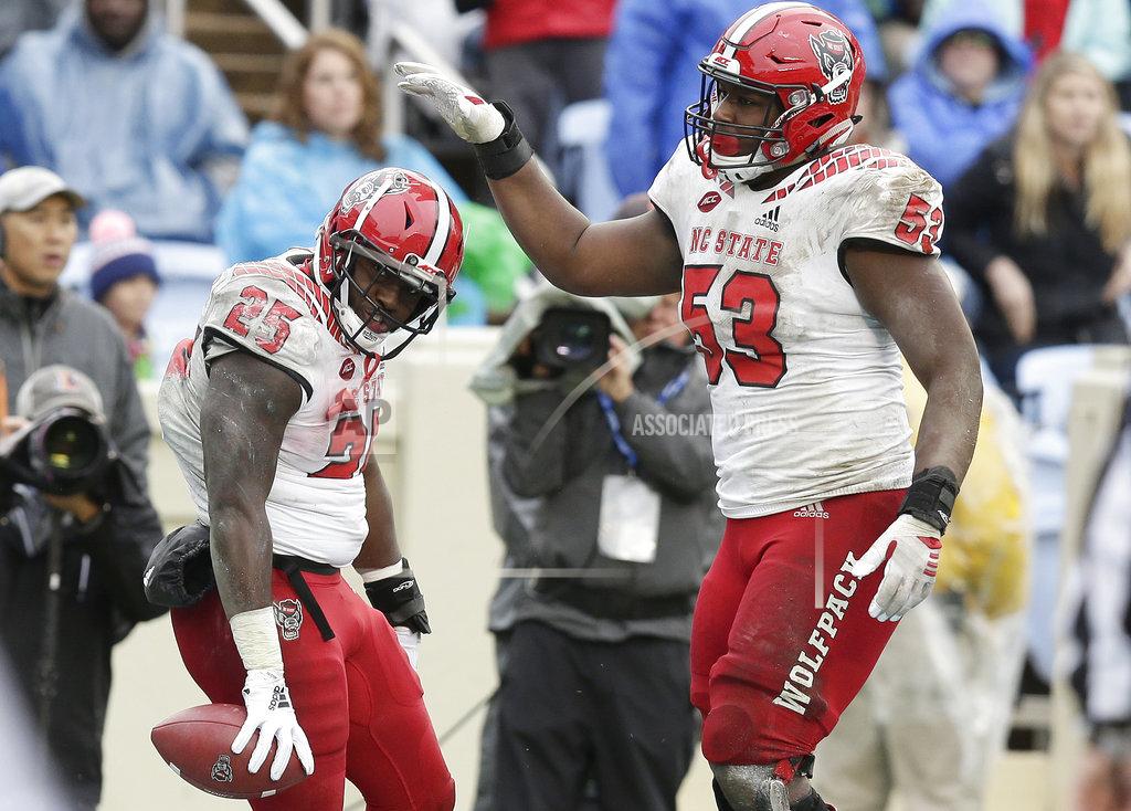Gerry Broome North Carolina State's Reggie Gallaspy II (25) and Tyler Jones (53) celebrate following Gallaspy's touchdown against North Carolina in the second half of an NCAA college football game in Chapel Hill, N.C., Saturday, Nov. 24, 2018. North Carolina State won 34-28 in overtime. (AP Photo/Gerry Broome)