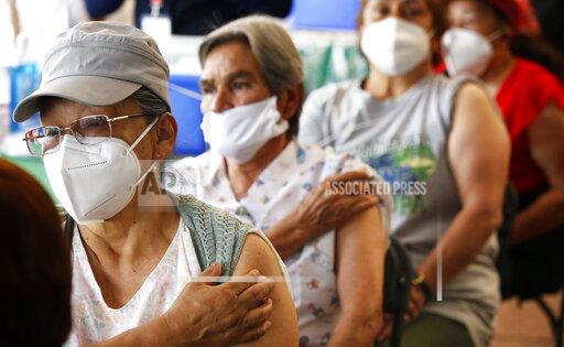 FILE - Persons over 60-years-old wait in observation after receiving their second dose of the AstraZeneca COVID-19 vaccine at the University Olympic Stadium in Mexico City, April 12, 2021. Mexican officials announced Tuesday, Nov. 30, 2021, that they have reversed their previous position against giving coronavirus booster shots and are studying a plan to administer third doses to people over 60. (AP Photo/Marco Ugarte, File)