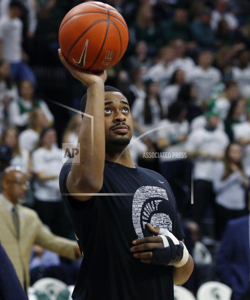 FILE - In this Feb. 20, 2019, file photo, Michigan State forward Nick Ward tosses a basketball before the second half of the team's NCAA college basketball game against Rutgers, in East Lansing, Mich. No. 6 Michigan State expects forward Nick Ward to play in the Big Ten Tournament. Coach Tom Izzo says he isn’t sure how much the 6-foot-9 junior will be able to play nearly a month after having surgery on his left hand. The top-seeded Spartans will face the winner of the Ohio State-Indiana game Friday in the conference quarterfinals. (AP Photo/Carlos Osorio, File)