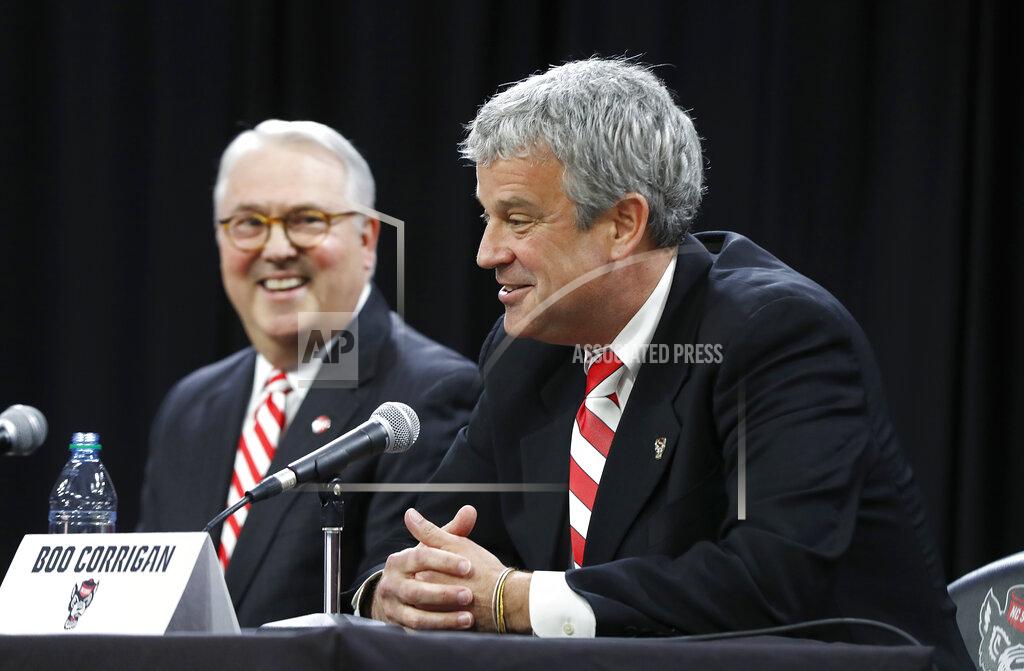 FILE - In this Jan. 31, 2019, file photo, North Carolina State chancellor Randy Woodson, left, laughs with Boo Corrigan after Corrigan was introduced as N.C. State's new athletic director, during a news conference in Raleigh, N.C. Corrigan has spent the first two months in the job getting to know the Wolfpack coaches and sorting out priorities for facility upgrades. He’s also getting used to the extra attention that comes with running a power-conference program. (Ethan Hyman/The News & Observer via AP, File)