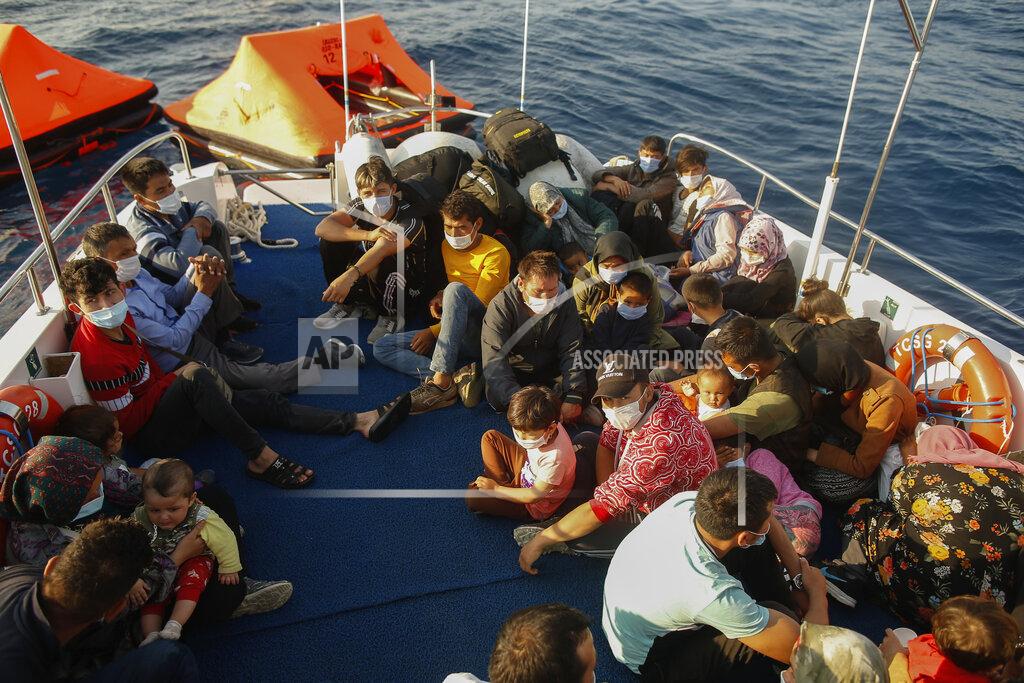 Emrah Gurel Migrants sit on a Turkish coast guard vessel after they were pulled off life rafts, during a rescue operation in the Aegean Sea, between Turkey and Greece, Saturday, Sept. 12, 2020. Turkey is accusing Greece of large-scale pushbacks at sea — summary deportations without access to asylum procedures, in violation of international law. The Turkish coast guard says it rescued over 300 migrants "pushed back by Greek elements to Turkish waters" this month alone. Greece denies the allegations and accuses Ankara of weaponizing migrants. (AP Photo/Emrah Gurel)