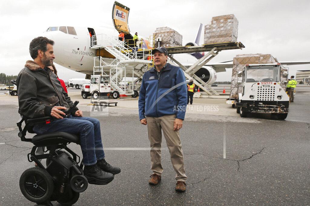 Charles Krupa New Hampshire Gov. Chris Sununu, right, talks with inventor Dean Kamen as over 110,000 pounds of personal protective equipment (PPE) from Shanghai, China, delivered to protect medical workers and first responders fighting the COVID-19 virus outbreak, is unloaded from a cargo plane at Manchester-Boston Regional Airport in Manchester, New Hampshire, Thursday, April 30, 2020. (AP Photo/Charles Krupa)