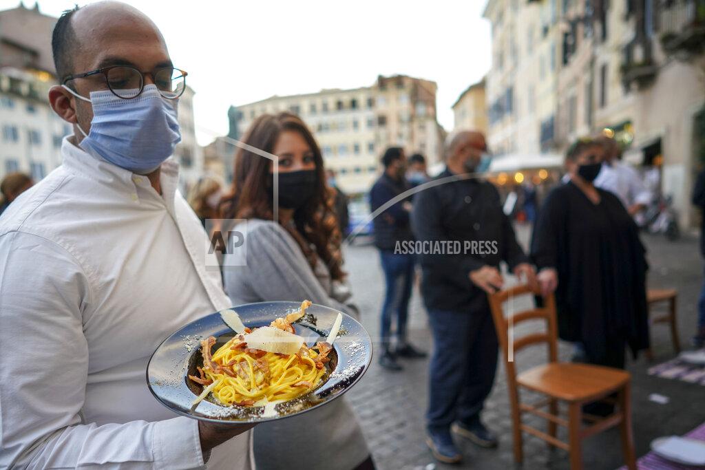 Andrew Medichini A man holds a plate of "Carbonara" spaghetti as restaurant owners protest against the government restriction measures to curb the spread of COVID-19, closing restaurants at night, in Rome, Wednesday, Oct. 28, 2020. For at least the next month cafes and restaurants must shut down in early evenings, under a decree signed on Sunday by Italian Premier Giuseppe Conte. (AP Photo/Andrew Medichini)
