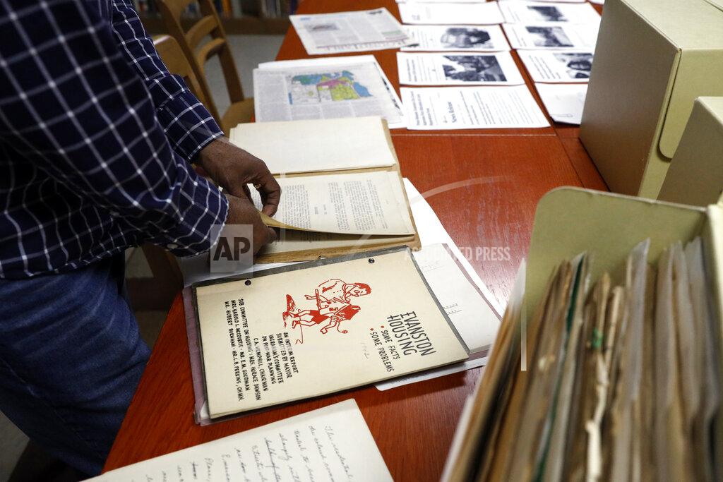 Shafkat Anowar Evanston's local historian Morris "Dino" Robinson Jr., looks through the archives in Shorefront Legacy Center in Evanston, Ill., Friday, April 9, 2021. The Chicago suburb is preparing to pay reparations in the form of housing grants to Black residents who experienced housing discrimination. “It’s a lot, a lot of work, and be prepared for pulling back old wounds, telling truth, gaining the trust,” said Robinson, who co-authored a city-commissioned study on housing practices. (AP Photo/Shafkat Anowar)