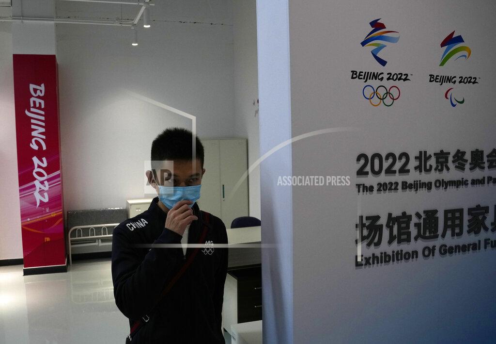 Ng Han Guan A worker walks by an exhibition of the furniture to be used for the upcoming Beijing Winter Olympics and Paralympics at the Main Distribution Center built to provide logistic support for the games in Beijing, China, Thursday, Dec. 9, 2021. The 34-meter-tall building has started operation at the end of last year to receive, store and distribute furniture, sport and technical equipment, and other materials for the current test events and next year's Winter Games. (AP Photo/Ng Han Guan)