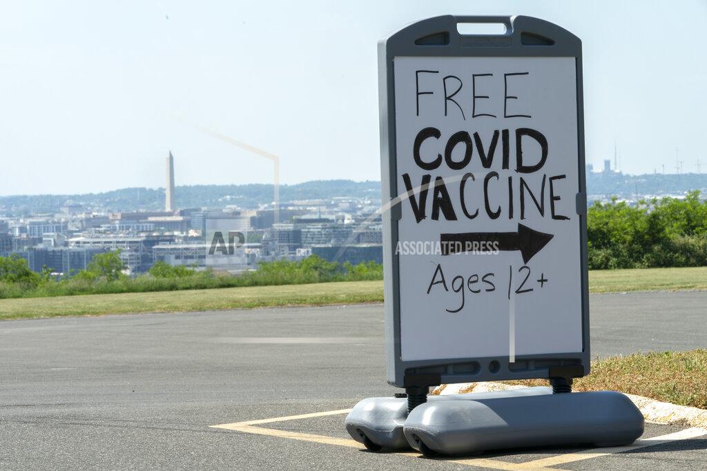 Jacquelyn Martin Overlooking downtown Washington and the Washington Monument, a sign advertises a free vaccine drive with Pfizer COVID-19 vaccinations for members of the community 12 years and up, Wednesday, May 19, 2021, at a clinic held by Community of Hope, outside the Washington School for Girls in southeast Washington. Neighborhood schools sent information about the vaccines to their students' families to ensure access to the vaccine, that's been recently approved for children ages 12-15. (AP Photo/Jacquelyn Martin)