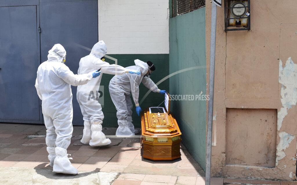 Edison Choco FILE - In this April 6, 2020 file photo, workers dressed in full protective gear pick up a coffin that contains the remains of a body, left on the side of a house in Guayaquil, Ecuador. In March and April, Guayaquil was a pandemic hellscape of makeshift morgues, hundreds dying at home, bodies left in the street. But Guayaquil has stabilized since then, sending medical teams and equipment elsewhere in Ecuador and taking in virus patients from outside the city. (AP Photo/Edison Choco, File)