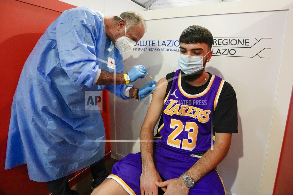 Andrew Medichini A student is administered his first dose of Pfizer/BioNTech Covid-19 vaccine, at a vaccination hub in a shopping mall in the outskirts of Rome, Tuesday, June 1, 2021. Eighteen-year-old students in Rome were administered their first dose of the Pfizer/BioNTech vaccine in Rome on Tuesday, in view of their upcoming final exams. The vaccination hub at the Porta di Roma Mall on the outskirts of Rome began vaccinating students ahead of their finals which begin in a few weeks. (AP Photo/Andrew Medichini)
