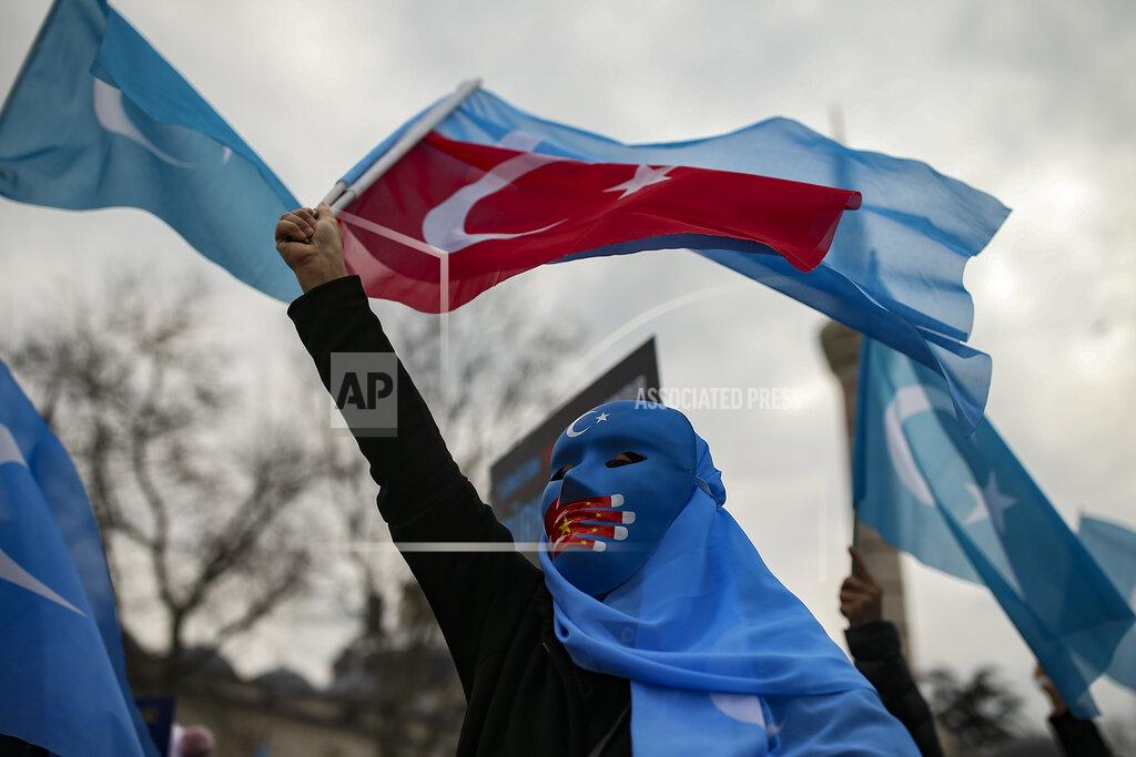 Emrah Gurel A protester from the Uyghur community living in Turkey waves a Turkish flag during a protest against the visit of China's Foreign Minister Wang Yi to Turkey, in Istanbul, Thursday, March 25, 2021. Hundreds of Uyghurs staged protests in Istanbul and the capital Ankara, denouncing Wang Yi's visit to Turkey and demanding that the Turkish government take a stronger stance against human rights abuses in China's far-western Xinjiang region. (AP Photo/Emrah Gurel)