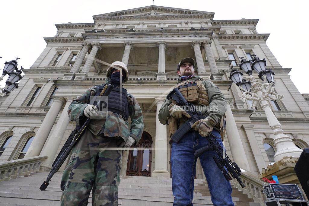 Paul Sancya FILE - In this Jan. 6, 2021 file photo, armed men stand on the steps at the State Capitol after a rally in support of President Donald Trump in Lansing, Mich. Statehouses where Trump loyalists have rallied since the Nov. 3 election are heightening security after the storming of the U.S. Capitol this week. Police agencies in a number of states are monitoring threats of violence as legislatures return to session and as the nation prepares for the inauguration of President-elect Joe Biden. (AP Photo/Paul Sancya, File)