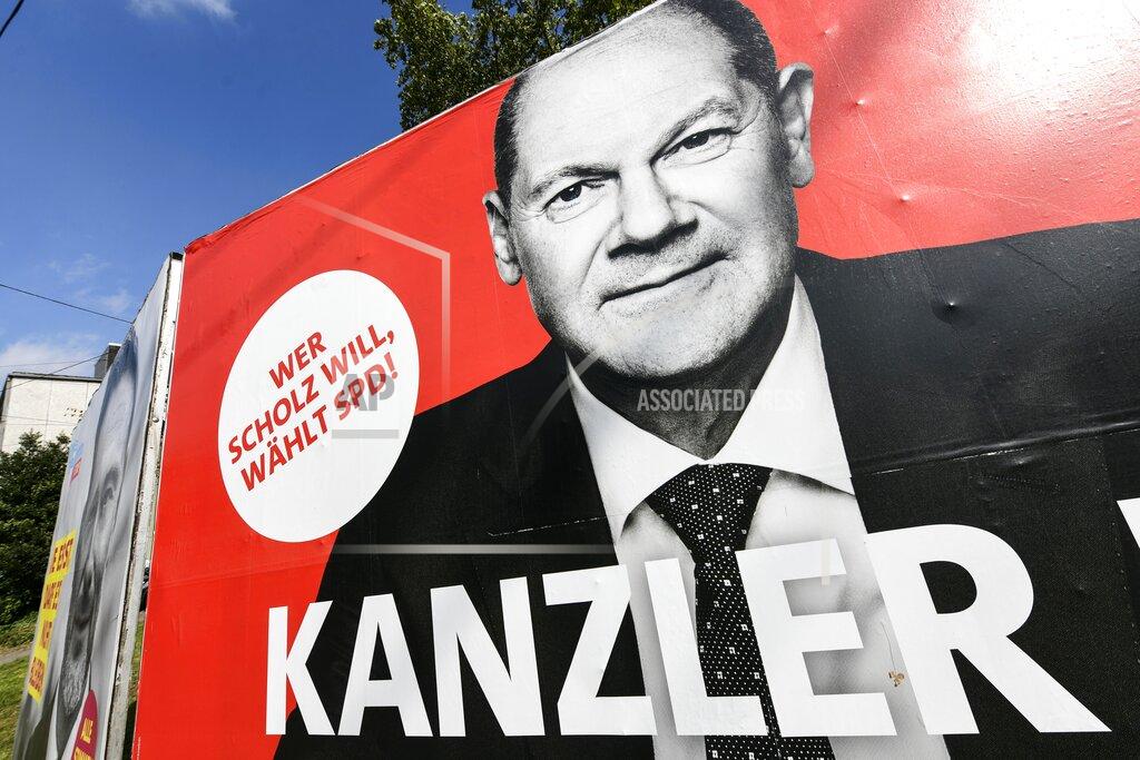 Martin Meissner An election poster of chancellor candidate Olaf Scholz, German Social Democrats (SPD), is pictured in a street in Gelsenkirchen, Germany, Thursday, Sept. 23, 2021 three days before the General election on Sunday, Sept. 26, 2021. Slogan reads: "Who wants Scholz, votes SPD! Chancellor". (AP Photo/Martin Meissner)