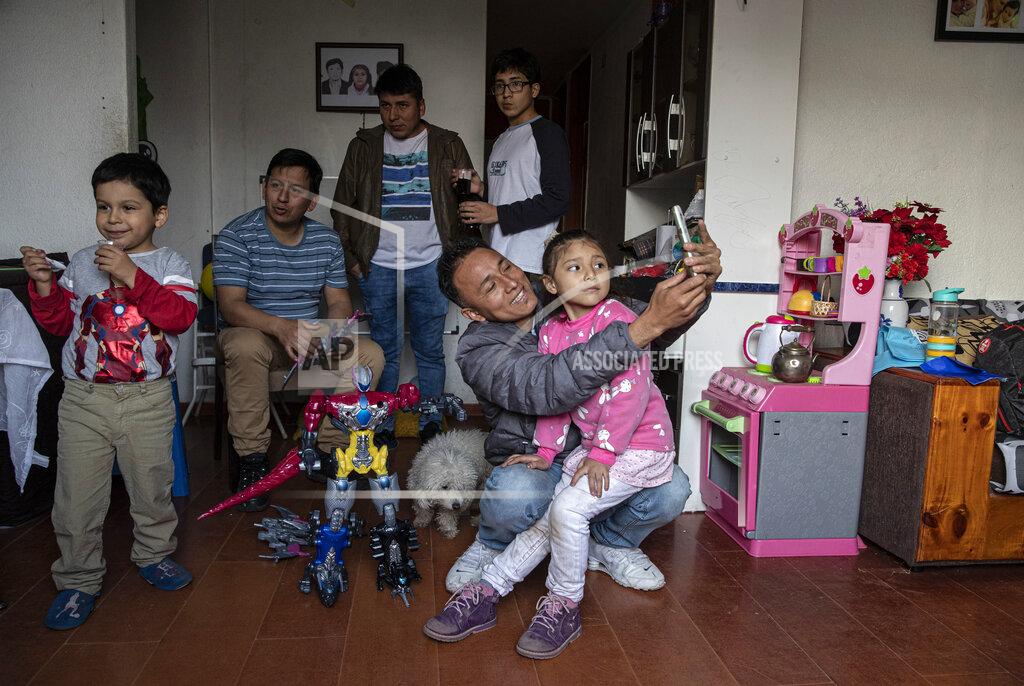 Esteban Felix Jose Collantes takes a selfie with his five-year-old daughter Kehity at a friend's birthday party in Santiago, Chile, Sunday, Aug. 23, 2020, two months after his wife, her mother, died of COVID-19. Their case highlights how COVID-19 deaths the world over are often the beginning of a new personal journey for those affected. (AP Photo/Esteban Felix)