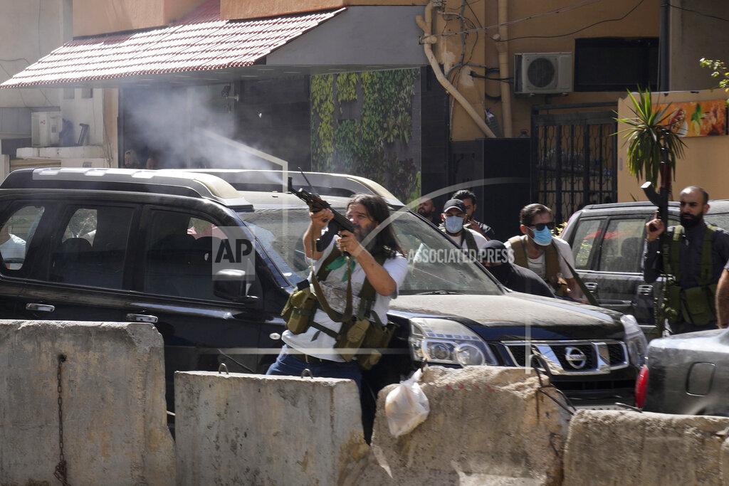 Hassan Ammar FILE - In this Oct. 14, 2021, file photo, supporters of a Shiite group allied with Hezbollah fire weapons during armed clashes that erupted during a protest in the southern Beirut suburb of Dahiyeh, Lebanon. The shootout on the streets of Beirut between rival Christian and Muslim groups has revived memories of the country's 1975-90 civil war and fired up sectarian passions in a country that never dealt with the causes of its violent past. (AP Photo/Hassan Ammar, File)