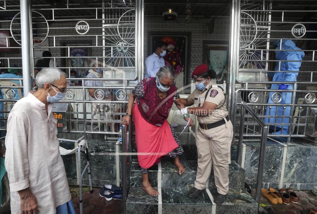 Rafiq Maqbool An elderly woman walks down a flight of stairs, helped by a policewoman, after she gave her swab sample, at a temple in Mumbai, India, Saturday, July 18, 2020. India crossed 1 million coronavirus cases on Friday, third only to the United States and Brazil, prompting concerns about its readiness to confront an inevitable surge that could overwhelm hospitals and test the country's feeble health care system. (AP Photo/Rafiq Maqbool)