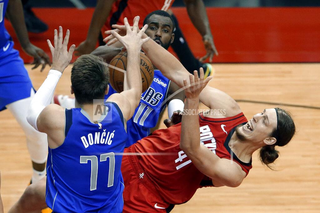 Michael Wyke Houston Rockets forward Kelly Olynyk (41) falls while vying for a rebound with Dallas Mavericks guard Luka Doncic (77) and forward Tim Hardaway Jr. (11) during the second half of an NBA basketball game Wednesday, April 7, 2021, in Houston. (AP Photo/Michael Wyke, Pool)