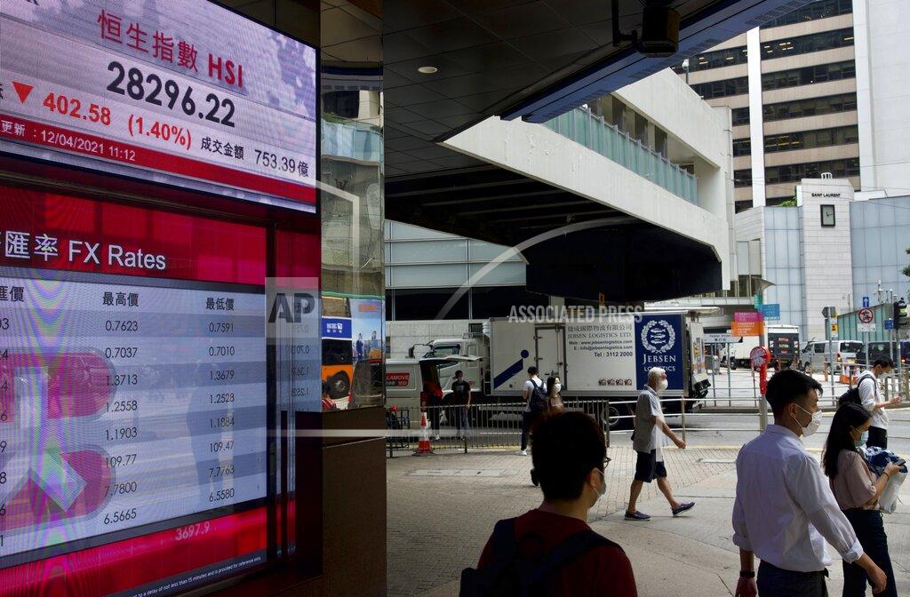 Vincent Yu People walk past a bank's electronic board showing the Hong Kong share index at Hong Kong Stock Exchange in Hong Kong Monday, April 12, 2021. Asian shares were lower on Monday, as investors grew wary over the recent surge in coronavirus cases in many places while vaccinations are making scant headway. (AP Photo/Vincent Yu)