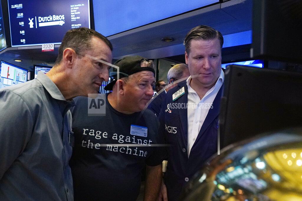 Richard Drew President and CEO of Dutch Bros Coffee Joth Ricci, left, and Travis Boersma, center, co-Founder and President, meet with specialist Gregg Maloney on the floor of the New York Stock Exchange, before their IPO, Wednesday, Sept. 15, 2021. (AP Photo/Richard Drew)