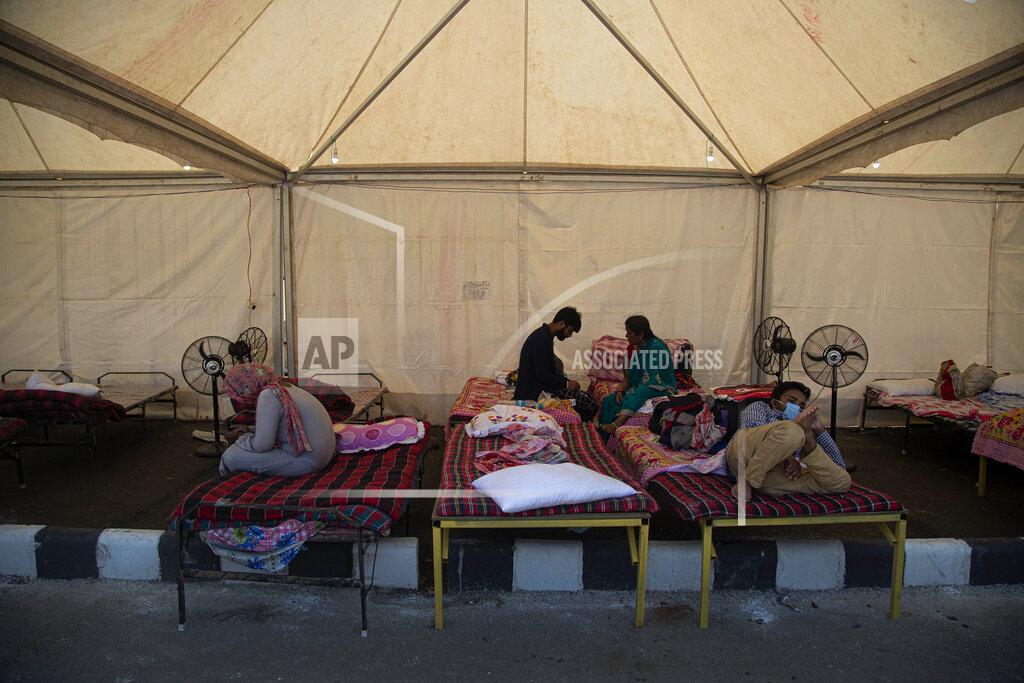 Migrant workers rest inside a tent before traveling in a Shramik train arranged to transport them to their home states, at a railway station in Gauhati, India, Thursday, May 28, 2020. Rural villages across India are seeing an increase in cases with the return of hundreds of thousands of migrant workers who left cities and towns where they were abandoned by their employers after having toiled for years building homes and roads. India sees no respite from the coronavirus caseload at a time when the two-month-old lockdown across the country is set to end on Sunday. (AP Photo/Anupam Nath)