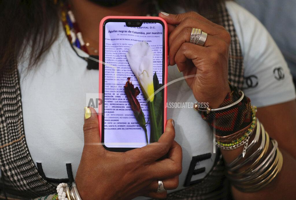 Fernando Vergara Community leader Luz Nelly Santana shows one of the many death threats she has received in Bogota, Colombia, Thursday, Dec. 17, 2020. The Afro-Colombian community leader sometimes uses a hat or a turban to disguise herself and always wears a bulletproof vest. (AP Photo/Fernando Vergara)