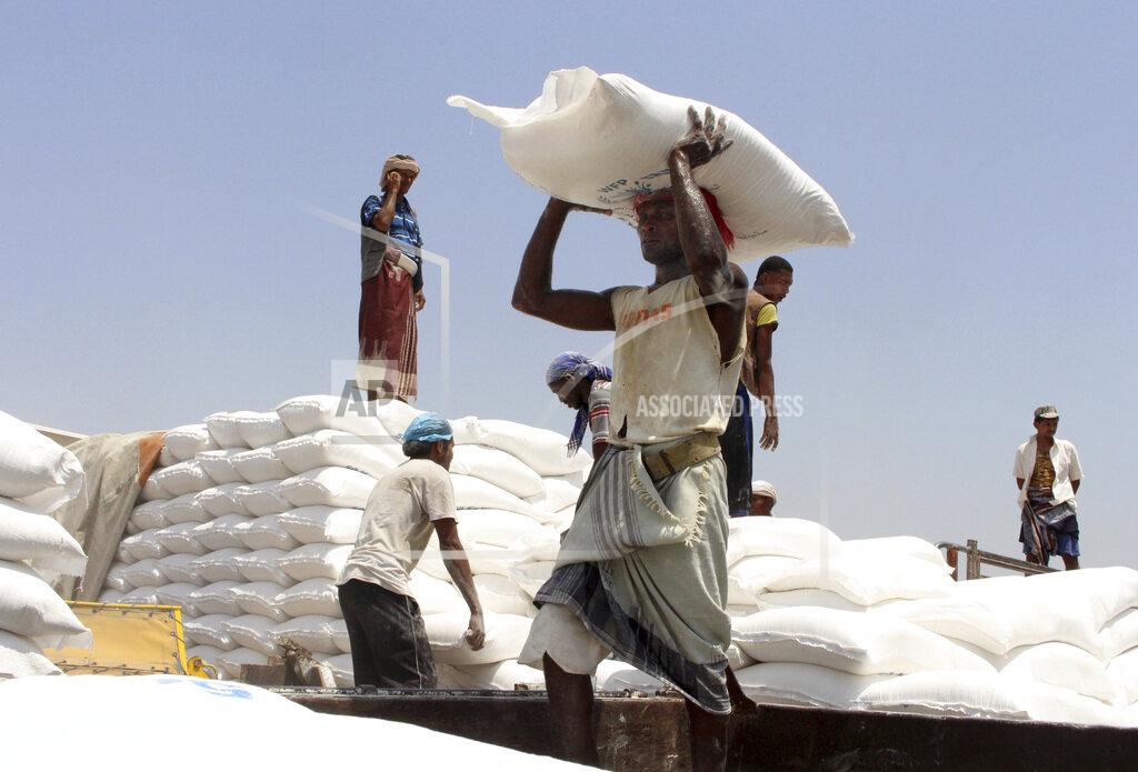 Hammadi Issa In this Sept. 21, 2018, file photo, men deliver U.N. World Food Programme (WFP) aid in Aslam, Hajjah, Yemen. The World Food Program chief warned Thursday, Sept. 17, 2020, that millions of people are closer to starvation because of the deadly combination of conflict, climate change and the COVID-19 pandemic and he urged donor nations and billionaires to help feed them and ensure their survival. (AP Photo/Hammadi Issa, File)