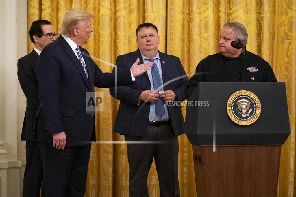 Evan Vucci President Donald Trump talks with Ford's Fish Shack employee Mark Underwood during an event about the Paycheck Protection Program used to support small businesses during the coronavirus outbreak, in the East Room of the White House, Tuesday, April 28, 2020, in Washington, as Treasury Secretary Steven Mnuchin, and Ford's Fish Shack founder Tony Stafford, and Underwood watch. (AP Photo/Evan Vucci)