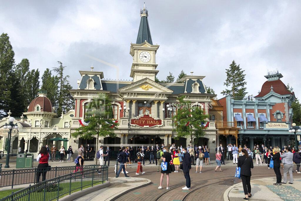Catherine Gaschka Visitors wait to enter Disneyland Paris in Marne-la-Vallée, east of Paris, Thursday, June 17, 2021. France's tourism sector takes a further step toward post-pandemic recovery with the reopening of Disneyland Paris, two weeks after the country formally welcomed back vaccinated foreign visitors. (AP Photo/Catherine Gaschka)