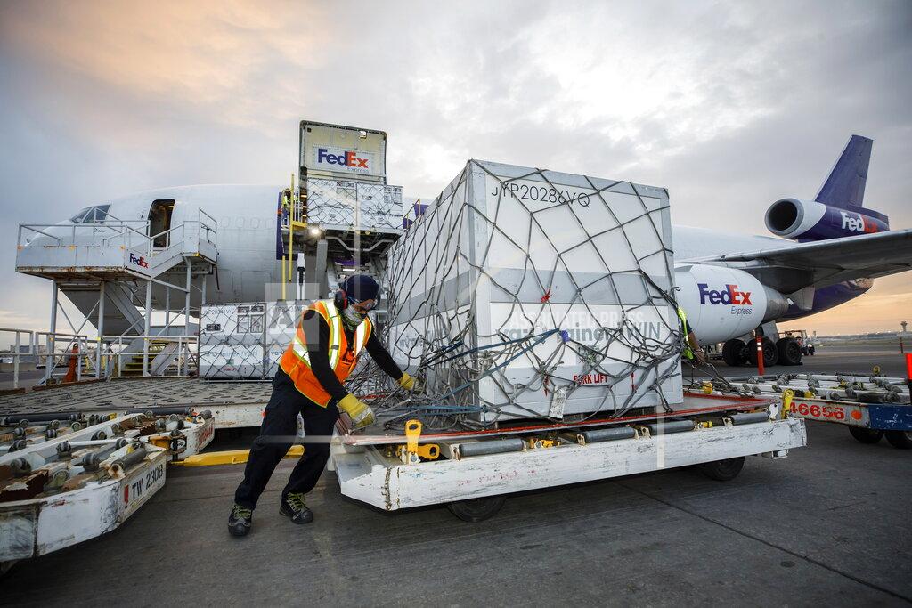 Workers unload a shipment of the Moderna COVID-19 vaccine at the FedEx hub at Pearson International Airport in Toronto on Thursday, May 20, 2021. (Cole Burston/The Canadian Press via AP)