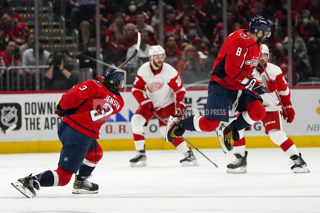 Alex Brandon Washington Capitals left wing Alex Ovechkin (8) jumps over a shot by Washington Capitals defenseman Nick Jensen (3) in the first period of an NHL hockey game against the Detroit Red Wings, Wednesday, Oct. 27, 2021, in Washington. (AP Photo/Alex Brandon)