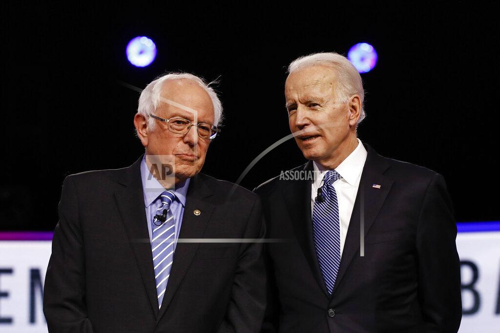Matt Rourke FILE - In this Feb. 25, 2020 file photo, Democratic presidential candidates, Sen. Bernie Sanders, I-Vt., left, and former Vice President Joe Biden, talk before a Democratic presidential primary debate in Charleston, S.C. Political task forces Biden formed with Sanders to solidify support among the Democratic Party's progressive wing recommended Wednesday, July 8, that the former vice president embrace proposals to combat climate change and institutional racism while expanding health care coverage and rebuilding a coronavirus-ravaged economy. (AP Photo/Matt Rourke, File)