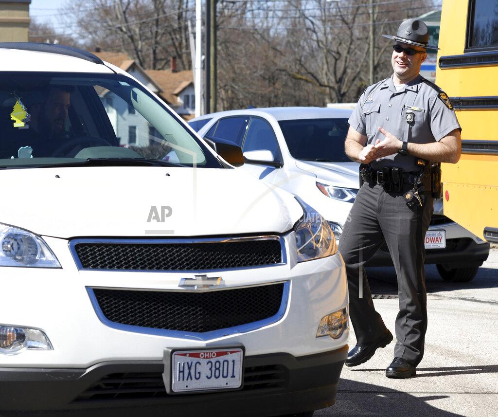 Warren Dillaway Ohio State Highway Patrol Sgt. Larry Johnson assists Ashtabula Area City Schools employees at a meal delivery site along Route 20 in Ashtabula, Ohio, on Thursday April 2, 2020, morning. (Warren Dillaway/The Star-Beacon via AP)