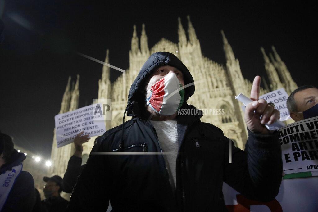Luca Bruno Workers stage a protest against the government restriction measures to curb the spread of COVID-19, in front of the Milan gothic cathedral, Italy, Thursday, Nov. 12, 2020. Italy's day-to-day case load of confirmed new COVID-19 infections climbed considerably higher on Thursday, as did the number of coronavirus patients needing ICU beds, which doctors say might not have enough specialists available to care for them. (AP Photo/Luca Bruno)