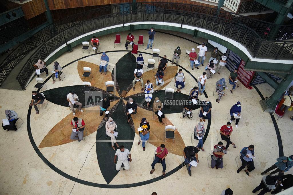 Dita Alangkara People wait for health screenings required before they receive the Sinovac COVID-19 vaccine during a mass vaccination in Jakarta, Indonesia, Monday, June 21, 2021. Indonesia's president ordered authorities to speed up the country's vaccination campaign as the World Health Organization warned of the need to increase social restrictions in the country amid a fresh surge of coronavirus infections caused by worrisome variants. (AP Photo/Dita Alangkara)