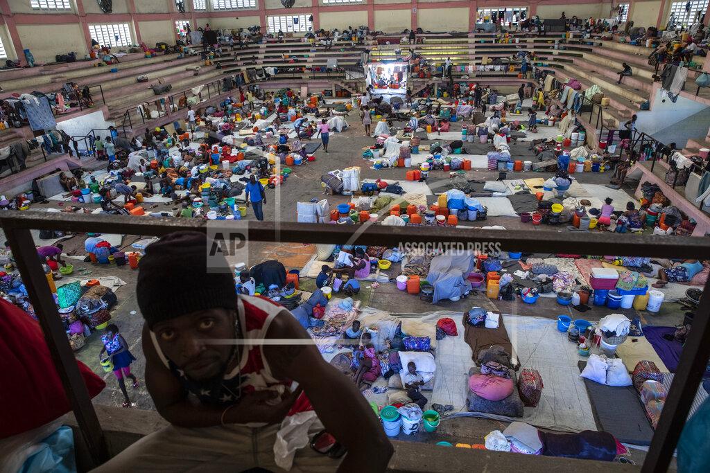 Rodrigo Abd Internally displaced people due to gang violence shelter in the Center Sportif of Carrefour, in Port-au-Prince, Haiti, Saturday, Sept. 18, 2021. Families with young children have been sleeping on concrete floors of the gymnasium since mid-June, with only a sheet serving as a bed and their scant belongings stuffed into bags nearby. (AP Photo/Rodrigo Abd)