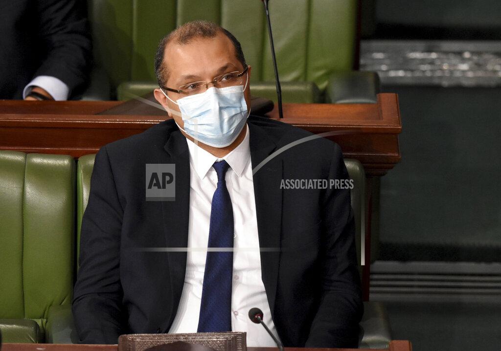 Hassene Dridi Tunisian Prime Minister Hichem Mechichi listens to debates as the government faces a confidence vote, Tuesday, Jan.26, 2021 at the Parliament in Tunis. Tunisians are marching on their heavily guarded parliament Tuesday as lawmakers vote on a new government, after a week of youth protests and riots over poverty and lack of jobs that left one young demonstrator dead and hundreds jailed. Prime Minister Hichem Mechichi announced a government reshuffle last week in the midst of the unrest. (AP Photo/Hassene Dridi)