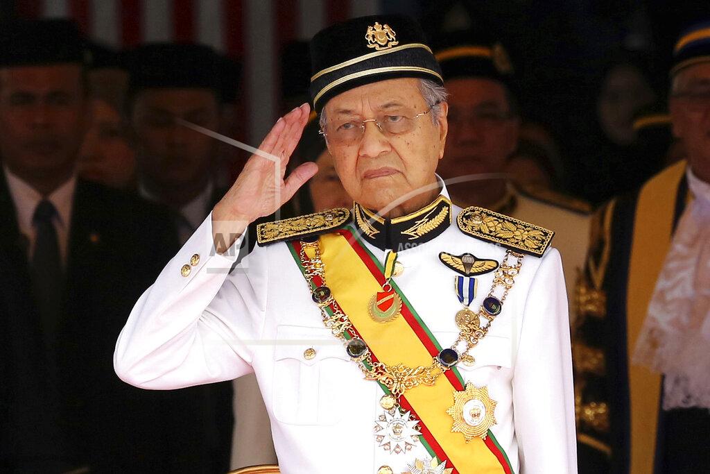 Yam G-Jun FILE - In this July 17, 2018, file photo, Malaysian Prime Minister Mahathir Mohamad salutes during the opening of the 14th parliament session at the Parliament house in Kuala Lumpur, Malaysia. Former Prime Minister Mahathir has been ousted from his Malay party in the latest twist to a power struggle with his successor Muhyiddin Yassin, but he has vowed to challenge the move. The 94-year-old Mahathir, along with his son and three other senior members, were expelled from the Bersatu party on Thursday, May 28, 2020. (AP Photo/Yam G-Jun, File)