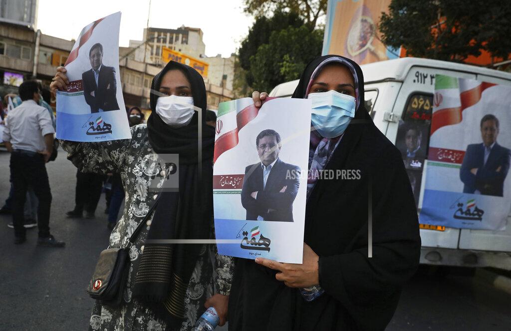 Vahid Salemi Supporters of Abdolnasser Hemmati, a presidential candidate in the June 18, elections, hold signs with his picture, during a street rally in Tehran, Iran, Tuesday, June 15, 2021. Hemmati, a prominent contender in Iran's presidential election appealed Tuesday for better economic and political relations with the West, his most extensive attempt yet to attract reformist voters just days ahead of the poll. (AP Photo/Vahid Salemi)