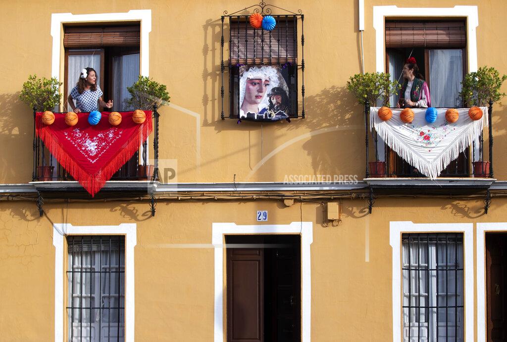 Miguel Morenatti In this photo taken on Thursday April 23, 2020, women in traditional dress sing on their decorated balconies in the village of Mairena del Alcor, some 21 kilometres (13 miles) from Seville during the annual traditional April Fair celebrated across the southern Andulacia Provence. Without breaking the confinement rules and maintaining their distance from each other, the residents of the village have found a novel way of continuing the tradition of the fair which has been cancelled due to the Coronavirus outbreak and normally includes flamenco dancing, bullfighting, eating and drinking. (AP Photo/Miguel Morenatti)